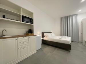 a bedroom with a bed and a kitchen with a microwave at B&B Stazione Nord in Busto Arsizio