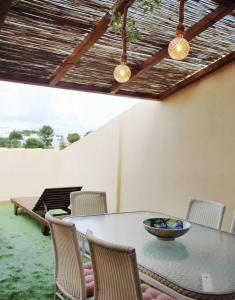 a table and chairs on a patio with a table and lights at Can Blau Formentera Apartamento in Es Pujols