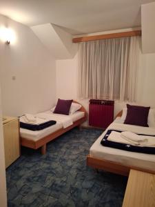 a hotel room with two beds and a window at Restoran Prenociste As in Trnovo