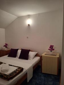 a hotel room with a bed and a nightstand with at Restoran Prenociste As in Trnovo