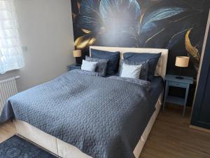 a bedroom with a bed with blue sheets and pillows at Apartament Elegancka Husarska in Wałbrzych