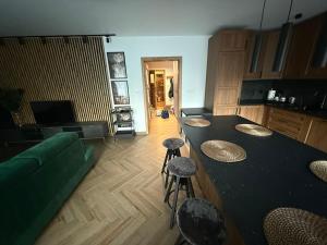 a living room with a green couch and a table and stools at Apartament Elegancka Husarska in Wałbrzych +29 photos