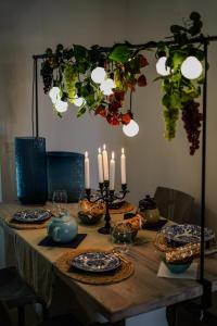 a table with candles and plates on it with a tableablish at CLavi Apartament in Sassari