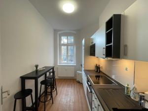 a kitchen with a counter and some stools in it at LS01 Deluxe Apartment, voll ausgestattet, zentral, groß in Magdeburg