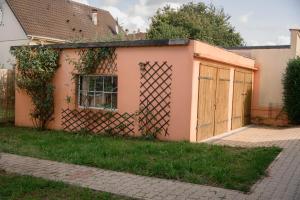 a pink house with a gate and a fence at Appartement Cosy in Basse-Yutz