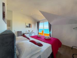 a bedroom with a large bed with a red blanket at Regina del Mare in Slatine