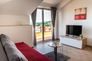 a living room with a couch and a flat screen tv at Regina del Mare in Slatine