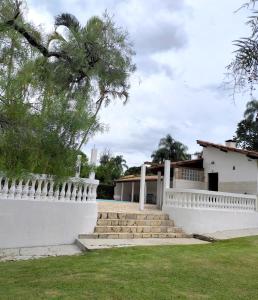 einen weißen Zaun und eine Treppe vor einem Haus in der Unterkunft Chácara Serra Negra in Serra Negra