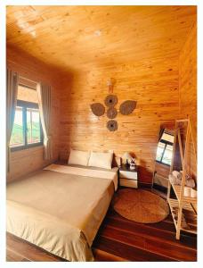 a bedroom with a bed in a wooden cabin at T'Gins Măng Đen Homestay in Kon Plong