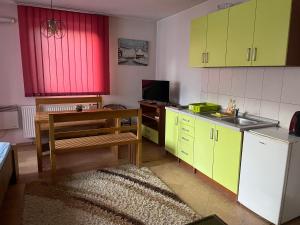 a kitchen with yellow and red cabinets and a sink at Sandy Vlašić in Vlasic