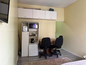 a room with two chairs and a refrigerator at Vitrine Estadia in Rio de Janeiro