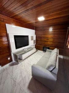 ein Wohnzimmer mit Couch und Flachbildfernseher in der Unterkunft Seu espaço em floripa! in Florianópolis