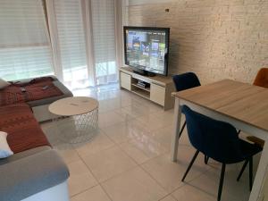 a living room with a couch and a tv and a table at T3 act in Pessac