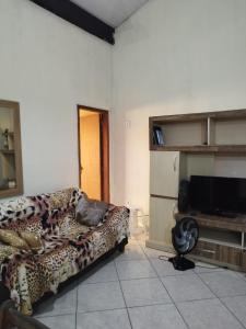 a living room with a couch and a television at Casa Lilytemporada in Cabo Frio