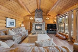 un soggiorno con camino in una baita di tronchi di Whitetail Springs Ranch a Custer