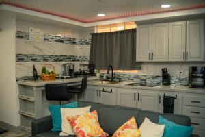 a living room with a couch and a kitchen at Lawrence Legacy Stays in Beaulieu