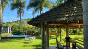 a pavilion with a table and chairs in a yard at Chalé Paradiso Biazolli in Farroupilha
