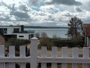 a white fence with a view of the water at Haus Seeblick in Alt Schwerin +5 photos