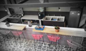 a model of a kitchen with pink chairs and a counter at Art & Coffee in Santa Cruz La Laguna
