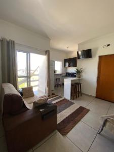 a living room with a couch and a table and a kitchen at Lofts Rocha Setville in São José dos Campos +18 photos