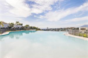 a large swimming pool with blue water at Luxury family apartment with breathtaking views in Marbella