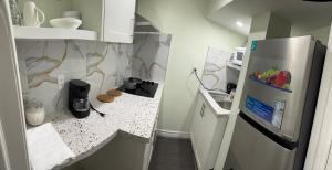 a small kitchen with a refrigerator and a counter at B01 cozy private room with bathroom in Mississauga