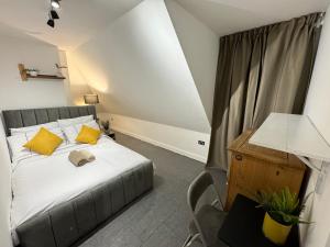 a bedroom with a bed with yellow pillows and a desk at A modern luxury penthouse close to London Tower-HIl-Canary Wharf-Central London in London