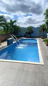 a swimming pool with a water fountain at Hospedaria Rancho Pérola in Guanambi