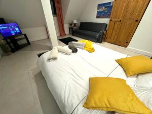 a large white bed in a living room with yellow pillows at A modern luxury penthouse close to London Tower-HIl-Canary Wharf-Central London in London
