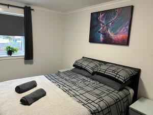 a bedroom with a bed with a picture of a deer on the wall at Spacious 2 bedroom apartment, entire place in Greenock