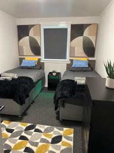 グリーノックにあるSpacious two bedroom apartment, entire placeのベッドが2つと大きな窓がある寝室