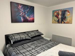 グリーノックにあるSpacious two bedroom apartment, entire placeのベッドと壁に絵が飾られた寝室 +4枚の写真