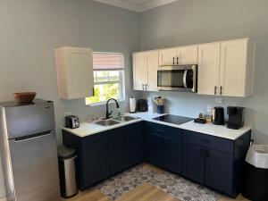 a kitchen with a sink and a refrigerator at Sunburst Studio in Turtle Cove