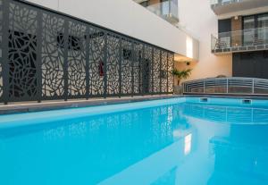 a swimming pool with a fence next to a building at Sunset Resort 011 Garden in Fonyód +18 photos