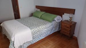 a bedroom with a bed with a wooden headboard and a night stand at Casa Ludi Valdeon in Prada
