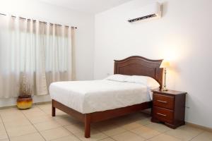 a bedroom with a bed and a table with a lamp at Real Paraiso in Juticalpa