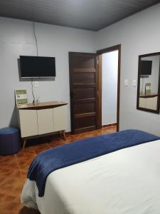a bedroom with a bed and a tv on the wall at Residência Vô José - Casa 02 in Pomerode