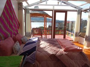a bedroom with a bed and a view of the water at Brisa del titicaca lodge in Puno