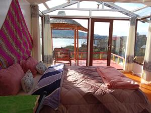 a bedroom with a bed and a view of the water at Brisa del titicaca lodge in Puno