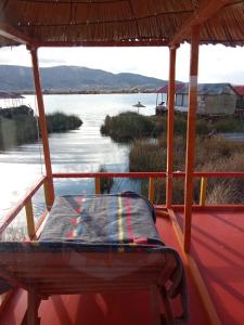 a bench on a porch with a view of a river at Brisa del titicaca lodge in Puno
