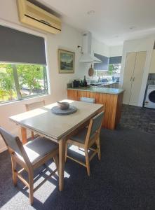 a kitchen and dining room with a table and chairs at The Kraken Cottage in Whitianga