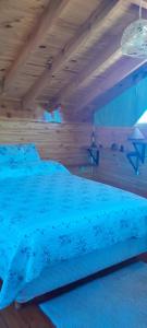 a bedroom with a blue bed with a wooden ceiling at Los Trevelinos in Trevelin