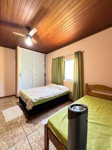 a bedroom with two beds and a ceiling fan at Sítio Canto da Seriema in Torrinha