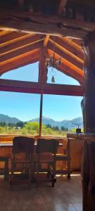 a room with a table and chairs and a view of a mountain at Los Trevelinos in Trevelin