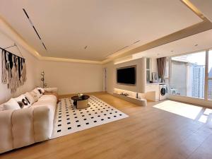a living room with a white couch and a tv at Eastern Hub - Three Bedroom Apt in Xintiandi, 50m from Metro, Many Shops and Malls Surrounded in Shanghai
