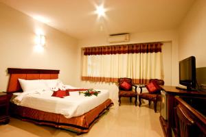 Habitación de hotel con cama y TV en Chiangrai Grand Room Hotel, en Chiang Rai