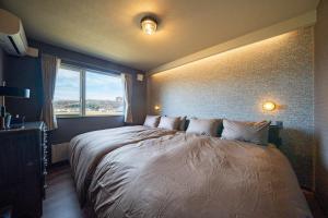 a bedroom with a large bed with a window at The Horizon Residence in Makubetsu