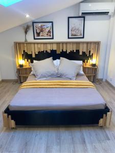 a bedroom with a large bed with a wooden headboard at Can FRANCES - Maison avec jardin et terrasse proche mer - linge de maison inclus in Villelongue-de-la-Salanque