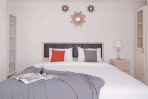 Un dormitorio con una gran cama blanca con almohadas rojas. en Comfortable and Homey 1BR Tamansari Bintaro Mansion Apartment By Travelio, en Tangerang 15 fotos más