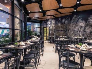 un restaurant avec des tables et des chaises dans une salle dans l'établissement Hotel Mercu Beneficência Portuguesa Bela Vista 1408, à São Paulo